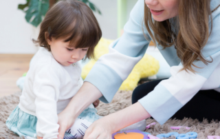 mom playing with daughter, pnc logo with champions for children logo